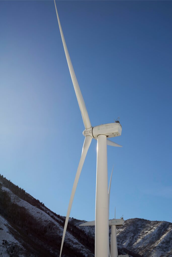 Majestic wind turbines in Utah mountains symbolizing clean renewable energy against a clear sky.